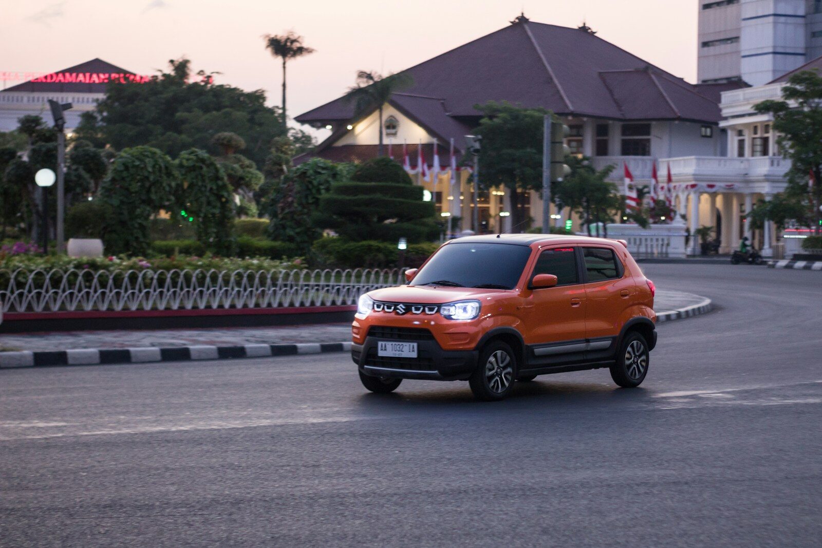 an orange truck driving down a street next to tall buildings